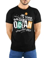 Summer Ocean Surfing Beach Graphic Tshirt Retro Coastal Vibes Style - model wearing black tee with hands behind back