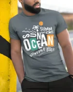 Summer Ocean Surfing Beach Graphic Tshirt Retro Coastal Vibes Style - model wearing grey tee, leaning on column