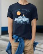Catch The Waves Surf Truck Beach Adventure Vintage Graphic Tee - model wearing navy tee with hands in pockets