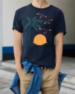 Retro Palm Tree Sunset Birds Coastal Beach Graphic Tee - model wearing navy tee with hands in pockets
