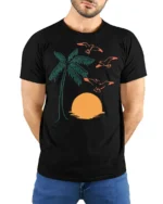 Retro Palm Tree Sunset Birds Coastal Beach Graphic Tee - model wearing black tee with hands behind back