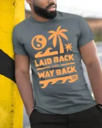 Laid Back Since Way Back Retro Beach Chill Vibes Graphic Tee - model wearing grey tee, leaning on column