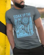 Soak Up The Sun Retro Surf Beach Vibes Graphic Tee Tshirt - model wearing grey tee, leaning on column