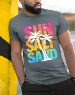 Sun Salt Sand Retro Tropical Beach Sunset Graphic Tee Tshirt - model wearing grey tee, leaning on column