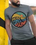 Here Comes The Sun Retro Vintage Sunshine Graphic Tee Tshirt - model wearing grey tee, leaning on column