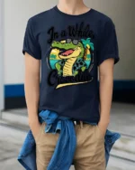In A While Crocodile Funny Vacation Graphic Tee Beach Humor - model wearing navy tee with hands in pockets