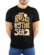 Raised By The Sea Beach Lover Graphic Tee Coastal Style - model wearing black tee with hands behind back