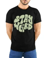 Stay Weird Retro Typography Graphic Tee Vintage Style Vibe - model wearing black tee with hands behind back