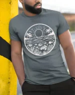 Ocean Sunset Marine Life Graphic Tee Coastal Nature Style - model wearing grey tee, leaning on column