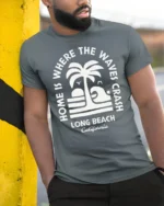 Long Beach California Waves Graphic Tee Retro Coastal Style - model wearing grey tee, leaning on column