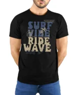 Surf Vibe Ride Wave Graphic Tee Retro Beach Adventure Style - model wearing black tee with hands behind back