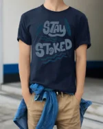 Stay Stoked Surf Graphic Tee Beach Lover Positive Vibes - model wearing navy tee with hands in pockets