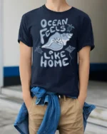 Ocean Feels Like Home Graphic Tee Coastal Beach Lover Style - model wearing navy tee with hands in pockets