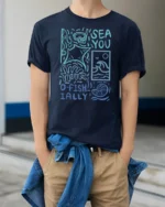 Sea You O Fishially Funny Ocean Graphic Tee Marine Humor - model wearing navy tee with hands in pockets