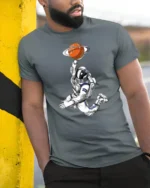 Astronaut Basketball Planet Graphic Tee Space Sports Style - model wearing grey tee, leaning on column