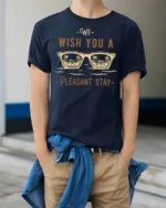 We Wish You A Pleasant Stay Vacation Vibes Graphic Tee - model wearing navy tee with hands in pockets