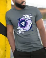 Not Likely Magic Eight Ball Graphic Tee Cosmic Humor Tshirt - model wearing grey tee, leaning on column