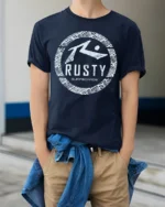 Rusty Surfboards Retro Surf Logo Beach Vibe Graphic Tee Tshirt - model wearing navy tee with hands in pockets