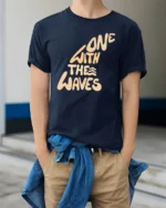 One With The Waves Ocean Vibe Surf Lifestyle Graphic Tee Cool Tshirt - model wearing navy tee with hands in pockets