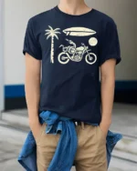 Retro Beach Motorcycle Surfboard Palm Tree Graphic Tee Tshirt - model wearing navy tee with hands in pockets