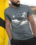 Go Where You Feel Most Alive Palm Beach Graphic Tee Tshirt - model wearing grey tee, leaning on column