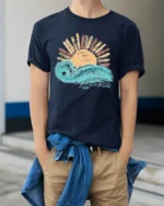 Take Me To The Ocean Wave Sunset Graphic T Shirt Tee - model wearing navy tee with hands in pockets