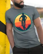 Retro Mountain Biking Sunset Graphic T Shirt Adventure Tee - model wearing grey tee, leaning on column