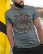 Swell Seeker Retro Surf Sunset Graphic Tee Beach Vibe Tshirt - model wearing grey tee, leaning on column