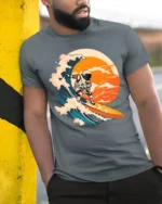 Astronaut Surfing Wave Graphic T Shirt Cosmic Ocean Tee - model wearing grey tee, leaning on column