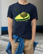Funny Avocado Surfboard Kayak Cartoon Food Lover T Shirt - model wearing navy tee with hands in pockets