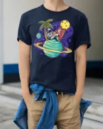 Funny Astronaut Surfing Planet Space Beach Vibes T Shirt - model wearing navy tee with hands in pockets