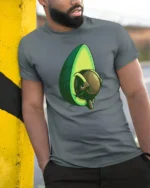 Funny Avocado With Big Attitude Cute Cartoon Food T Shirt - model wearing grey tee, leaning on column