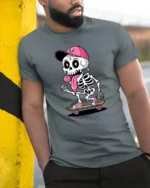 Funny Skateboarding Skeleton With Lollipop Cute Cartoon T Shirt - model wearing grey tee, leaning on column