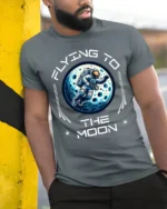 Flying To The Moon Astronaut Space Adventure Graphic T Shirt - model wearing grey tee, leaning on column