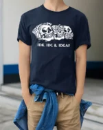 Sarcastic Skull Trio IDK IDC IDGAF Humor Graphic Tee Shirt - model wearing navy tee with hands in pockets