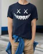 Creepy Smile Skull Face X Eyes Minimalist Graphic T Shirt - model wearing navy tee with hands in pockets