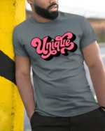 Groovy Pink Script Unique Typography Bold Retro Graphic Tshirt - model wearing grey tee, leaning on column