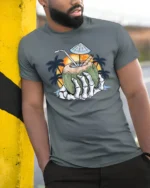 Tropical Skeleton Hand Coconut Cocktail Beach Graphic Tee - model wearing grey tee, leaning on column