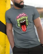 Brainy Undead Zombie Sticking Tongue Out Graphic Tshirt - model wearing grey tee, leaning on column