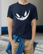 Grinning Cheshire Monster Toothy Smile Graphic Tshirt - model wearing navy tee with hands in pockets