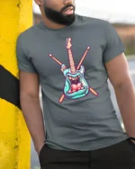 Teal Rock Monster Guitar Crossed Drumsticks Graphic Tshirt - model wearing grey tee, leaning on column