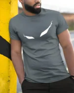 Haunting Ghostly Eyes Wispy Trail Mystery Graphic Tee - model wearing grey tee, leaning on column