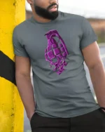 Explosive Skull Grenade Fragment Purple Bone Graphic Tshirt - model wearing grey tee, leaning on column