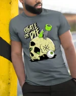 Daring Skate Or Die Skull Green Wheels Graphic Retro Tshirt - model wearing grey tee, leaning on column