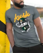 Dope Kush Ville Stoner Raccoon Smoking Blunt Graphic Tshirt - model wearing grey tee, leaning on column