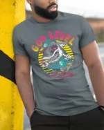 Rad God Level Surfing Shark Retro Sunset Graphic Tshirt - model wearing grey tee, leaning on column