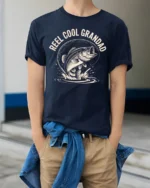 Reel Cool Grandad Fishing Bass Vintage Graphic Tshirt - model wearing navy tee with hands in pockets