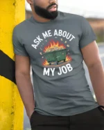 Humorous Dumpster Fire Ask Me About My Job Slogan Tshirt - model wearing grey tee, leaning on column