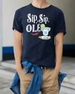 Festive Sip Sip Ole Margarita Cocktail Slogan Graphic Tee - model wearing navy tee with hands in pockets