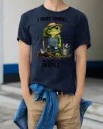 Funny Frog Gardener I Bury Things Sarcastic Graphic Tee - model wearing navy tee with hands in pockets